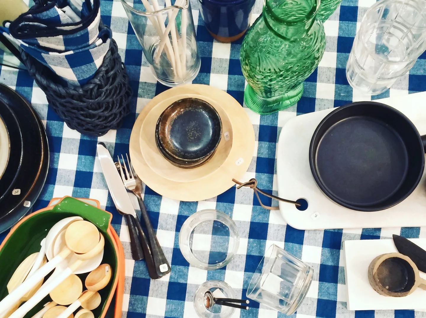 Table dressée sur une nappe vichy bleue, assiettes et verres colorés