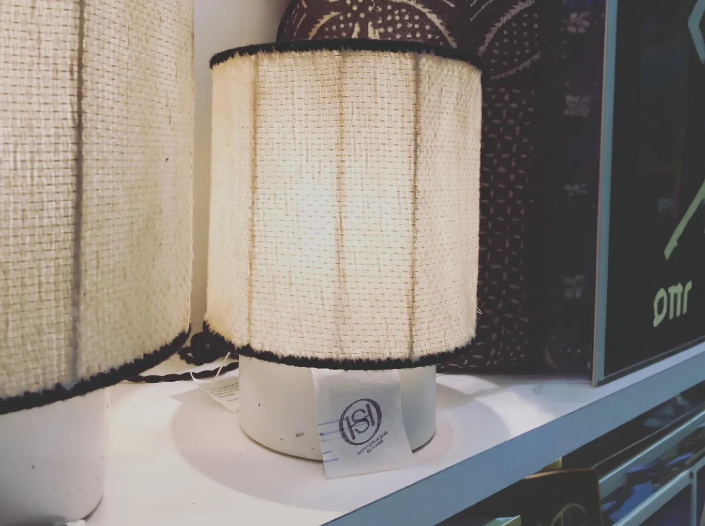 Lampes à abat-jour en toile écrue sur une étagère de la boutique